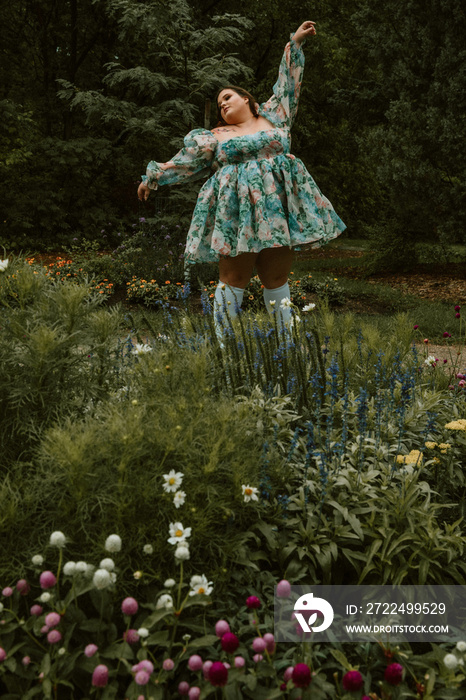 portrait of a plus size woman dancing in a garden