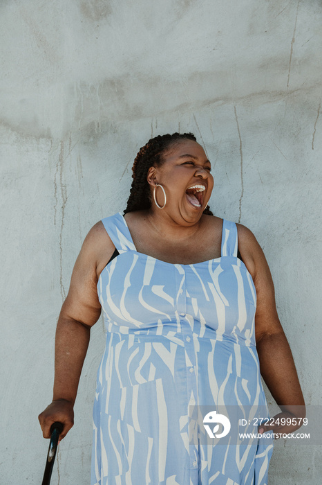 Afro Latinx Haitian American laughing and holding a cane