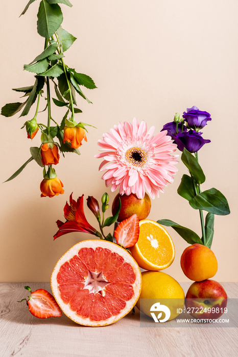 Floral and fruit composition with roses, Eustoma, gerbera, Alstroemeria, citrus fruits, strawberries and peaches on beige background