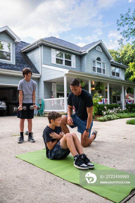 Air Force service member trains with his sons in a morning workout in preperation for a PT fitness test.