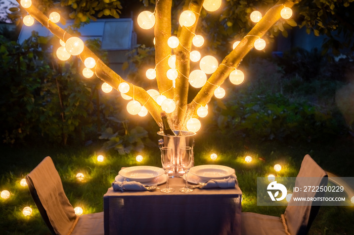 Romantic table for two with champagne in summer garden