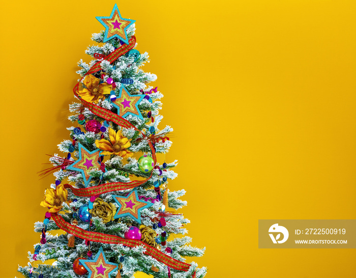 黄色背景下的彩色圣诞树