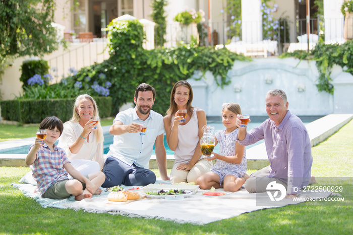 Portrait happy multi-generation family enjoying picnic in sunny garden