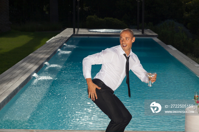 Playful young man dancing at poolside party