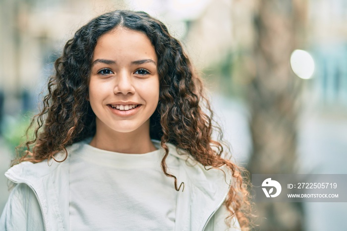 Hispanic teenager girl smiling happy standing at the city.