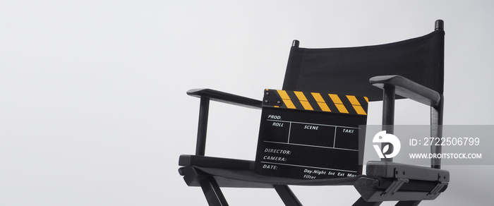 白色背景上有黑色和黄色拍板或电影石板的导演椅。它用于