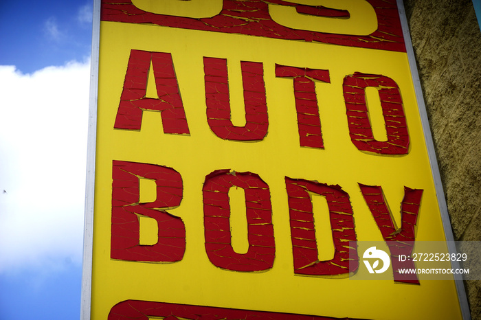 aged and worn auto body shop sign