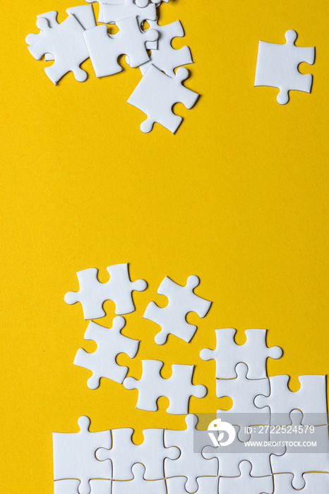 Jigsaw puzzles placed on a yellow background Creative concept with copy space