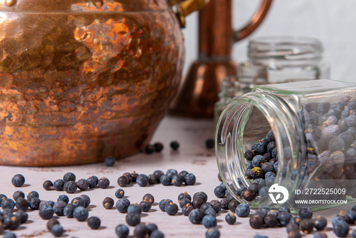 Alambique de cobre utilizado para destilar con botánicos, enebro, cardamomo y accesorios sobre una m