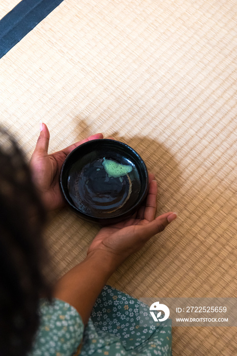 在日本传统节日期间，黑人妇女在喝了抹茶后，亲手归还茶碗