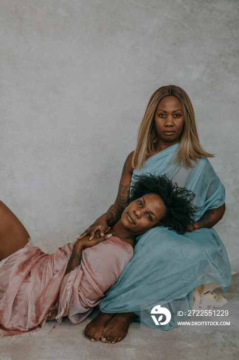 Portrait of African American woman with head resting on the lap of another African American woman