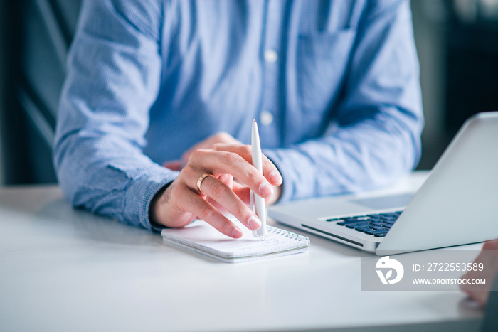 Close-up image of businessman taking notes.