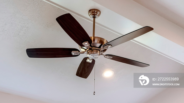 Panorama Decorative wood beam with standard ceiling fan and lights inside a house