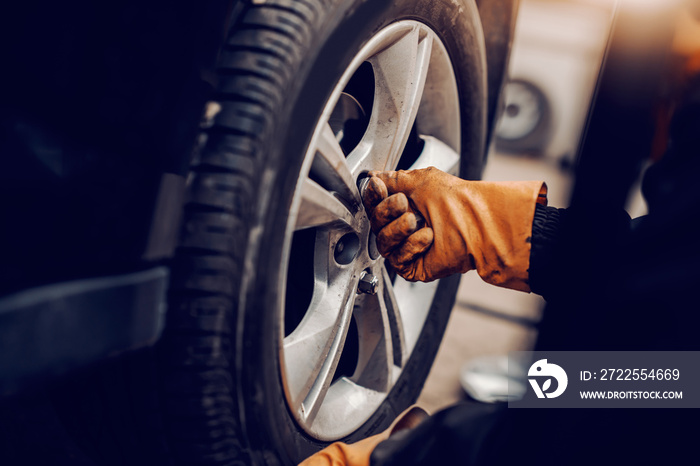 汽车修理工在车间更换轮胎的特写。