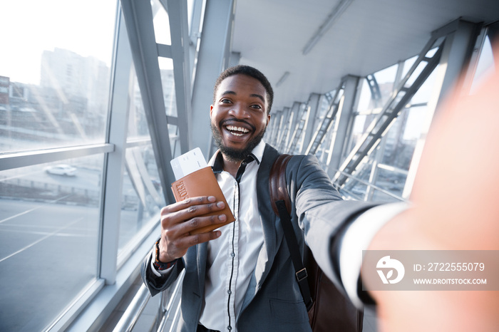 Excited Businessman Taking Selfie In Airport, Holding Passport