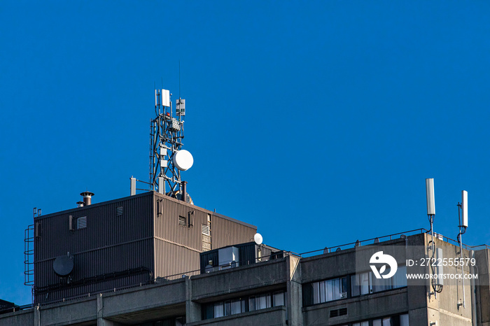 View of the top of an industrial building equipped with various GPS, cellphone, 3G, 4G and 5G teleco