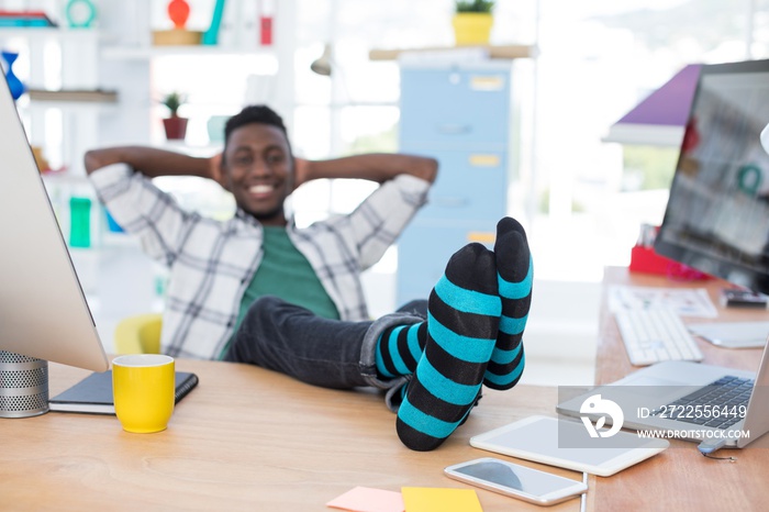 Male executive relaxing at his desk in office