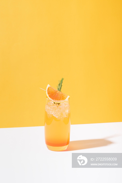 冷而清爽的橙色潘趣鸡尾酒，背景是橙色切片。夏季饮料。