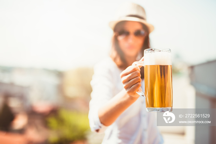 Beautiful young woman drinking beer and enjoying summer day.