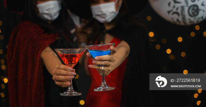 women in witches costume wearing face mask with balloon for halloween party