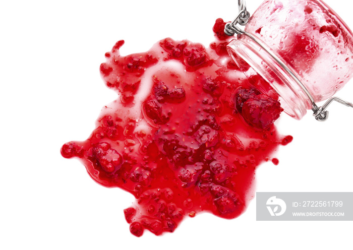 白色背景上的玻璃罐和溢出的树莓酱