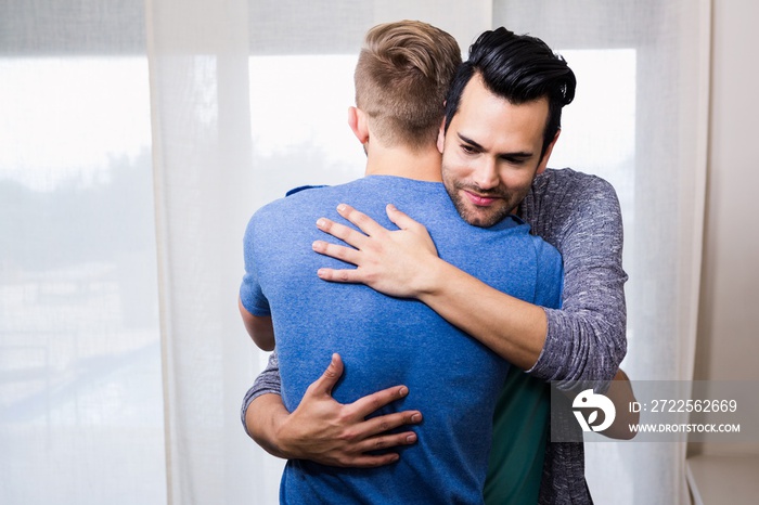 Smiling gay couple embracing