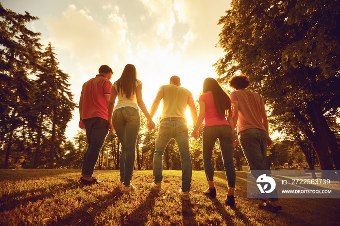 A group of happy people at sunset on the nature.