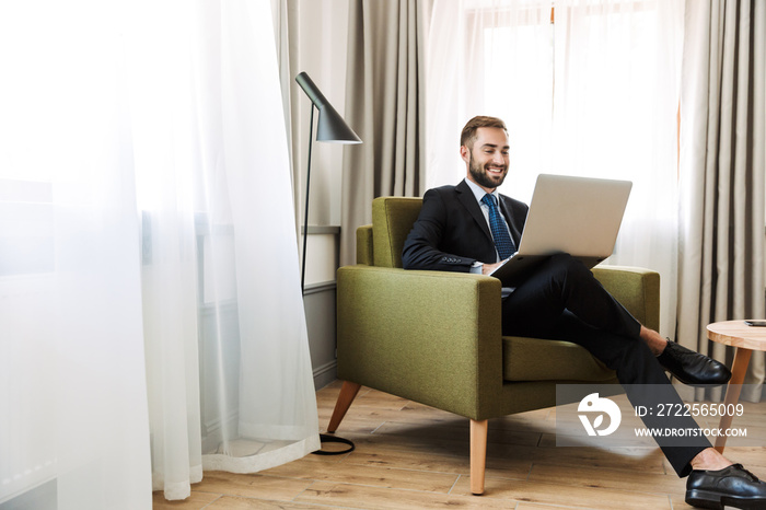 Attractive young businessman wearing suit sitting in a chair