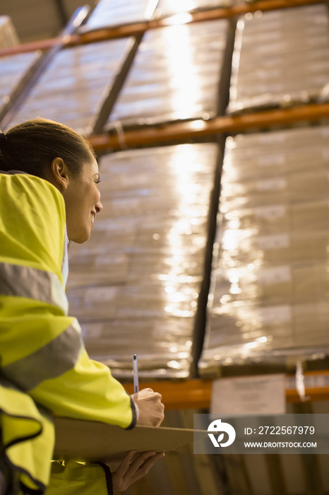 Female worker checking inventory in distribution warehouse