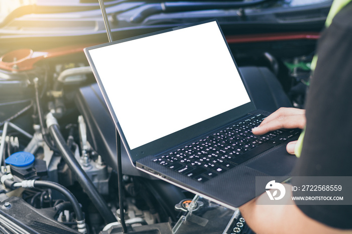 Close up engineer  mechanic using electrnoic diagnostic equipment to tune a car, Laptop blank screen