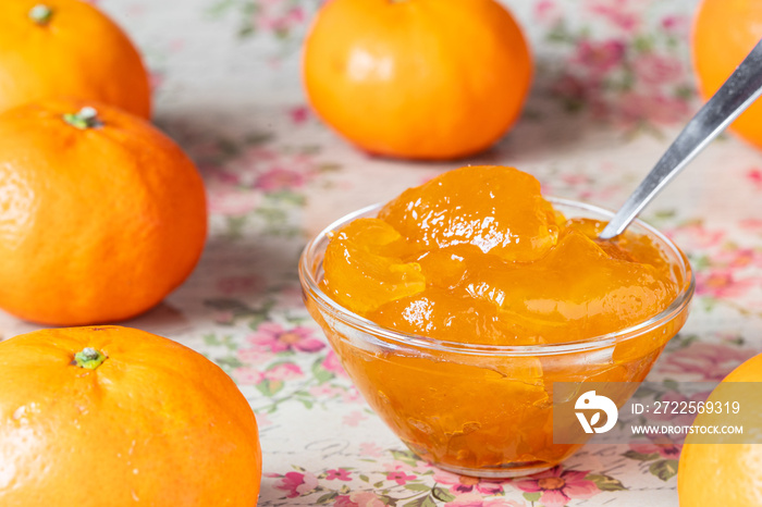 frische orange Mandarinenmarmelade in Schüssel auf vintage Untergrund mit Rosen und Blumen