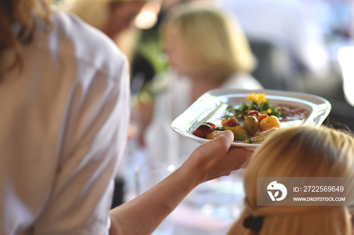 Bedienung serviert Essen für die Gäste im Restaurant