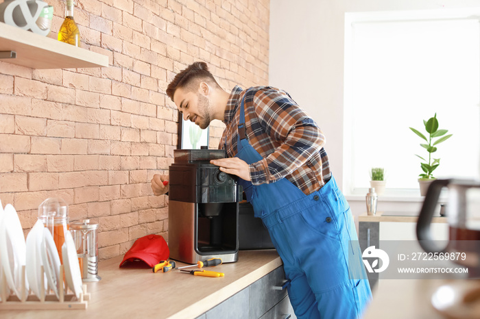 Man repairing coffee machine in kitchen