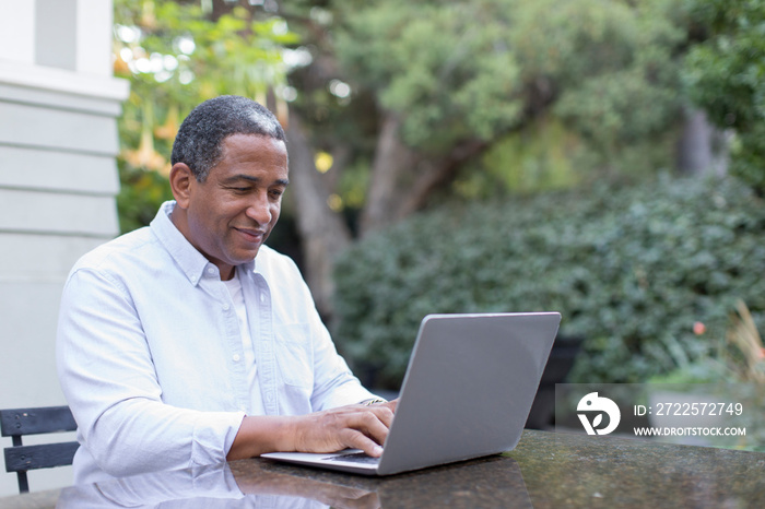 Senior man using laptop on patio