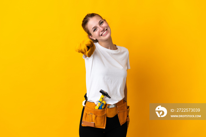 Young electrician woman isolated on yellow background points finger at you with a confident expressi