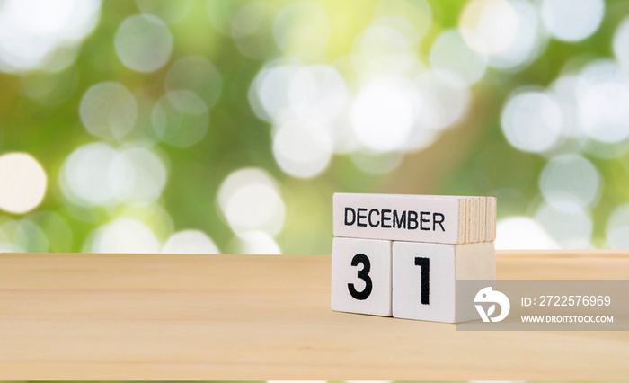 31 December wooden cube calendar on wood surface with copy space ,bokeh blackground