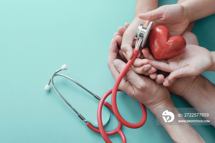 Family hands holding red heart with stethoscope, heart health,  health insurance concept, World hear