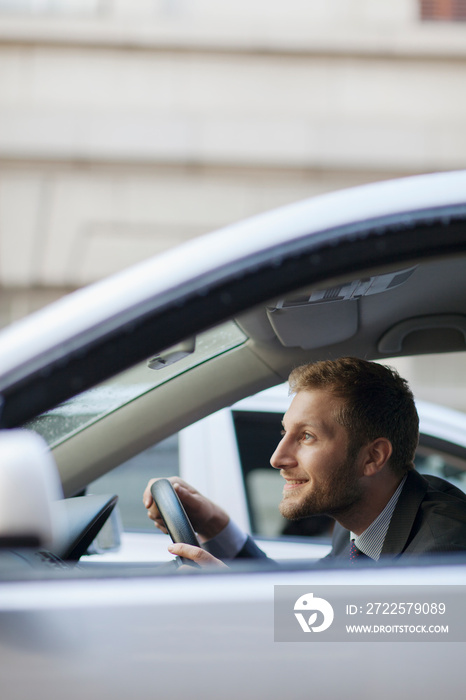 Smiling businessman driving car