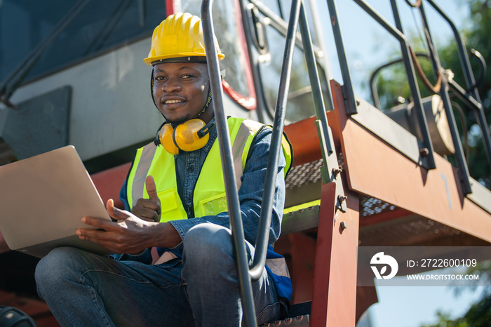 African workers, Engineer, Technician holding laptop for checking and inspecting on Heavy machine engine. foreman repairing a part of machine for heavy industrial.