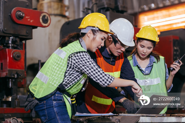 Asian male engineer or foreman worker training female trainee using program or system in industry manufacturing factory. teamwork and corporate people working hard in industrial construction site