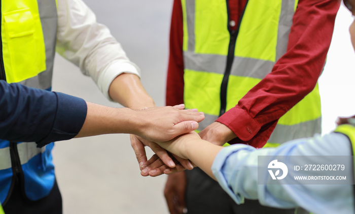 Group of technician engineer or worker in protective uniform with hardhat standing and stacking hands celebrate successful together or completed deal commitment at heavy industry manufacturing factory