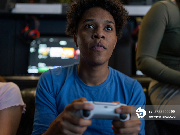 Serious man playing video games with friends in gaming club