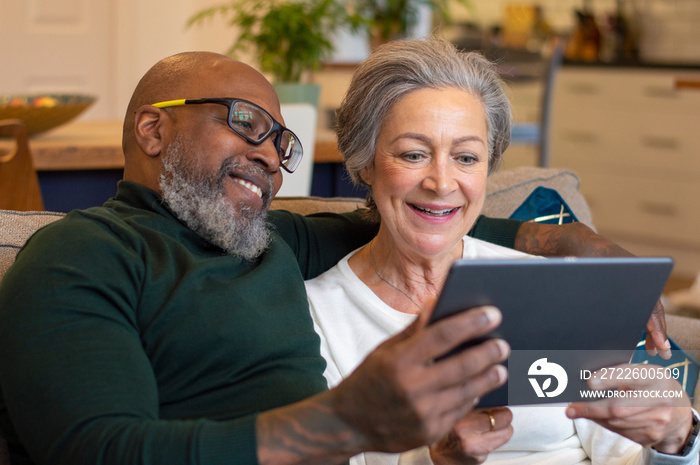 Senior couple using digital tablet at home