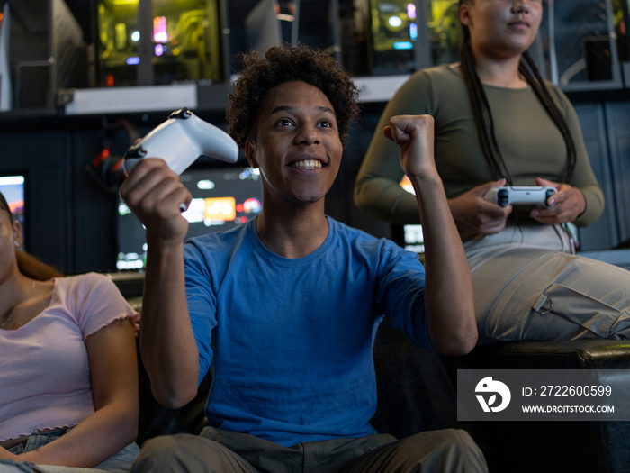 Excited man playing video games with friends in gaming club