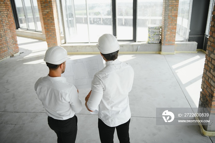 Two Specialists Inspect Commercial, Industrial Building Construction Site. Real Estate Project with Civil Engineer