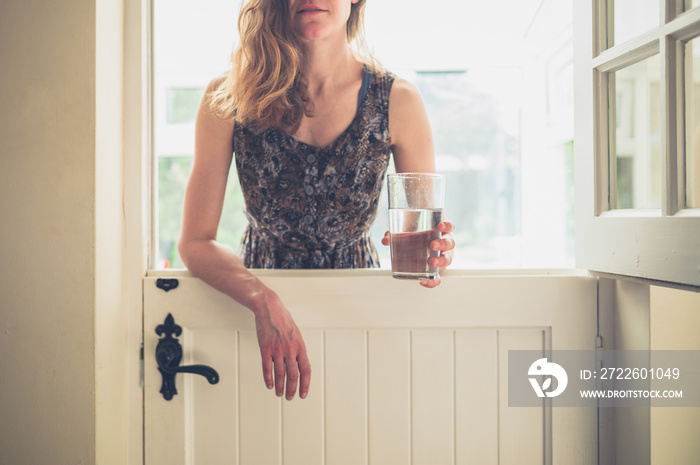 Woman with glass by stable door