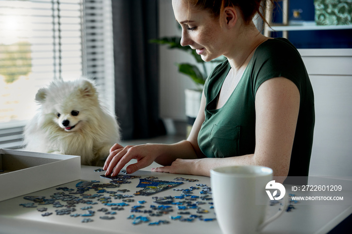 Young woman doing jigsaw puzzles