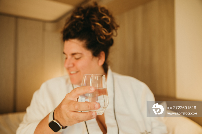 close up of a woman’s hands holding a cup of water