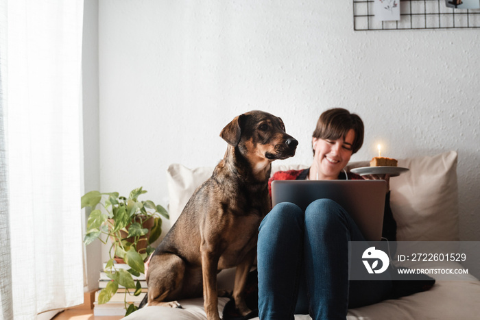 young girl celebrating birthday at home on video call at home - Focus on dog pet