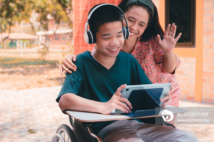 Special need child on wheelchair use a tablet in the house with his parent, Study or Work at home for safety from covid 19, Life in new normal education of special need kid,Happy disabled boy concept.